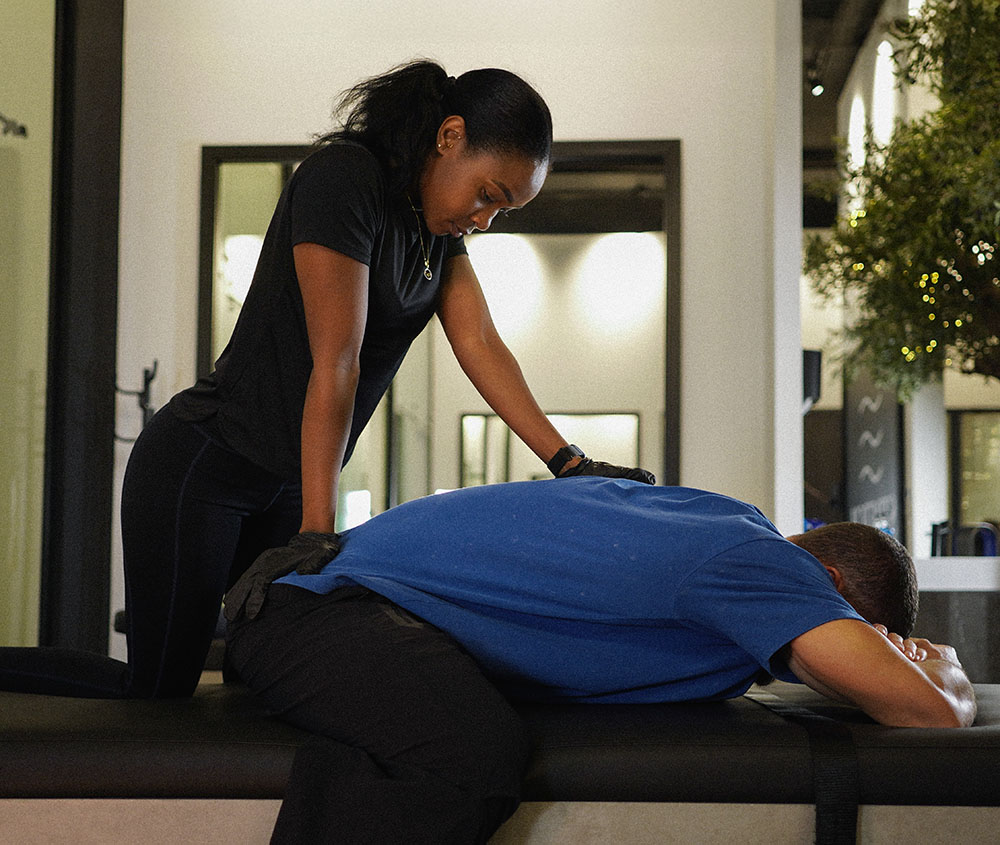 A therapist applying pressure to a client’s back
