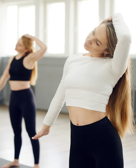 Two women doing neck stretches